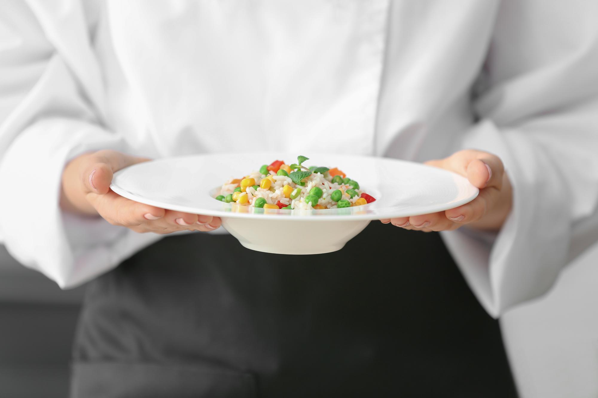Cook handing over a plated tasting portion